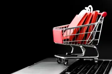 Carrinho de compras com notebook e fundo preto para black friday